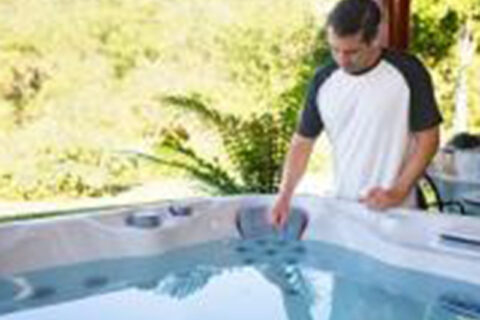 a man checking water in hot tub